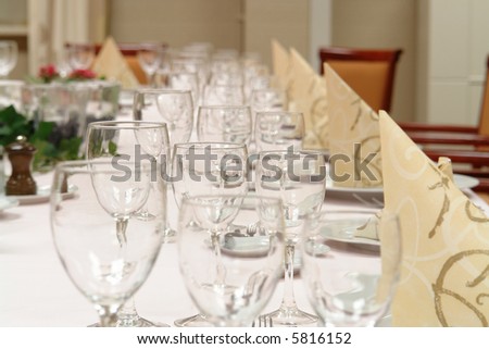large dinner table set up for a lot of people - focus on the second set of glasses