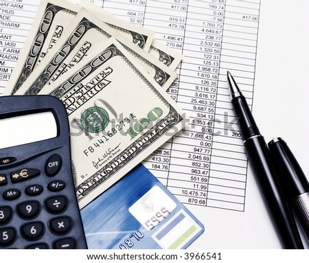 financial statement, calculator, banknotes and pen on top of financial documents