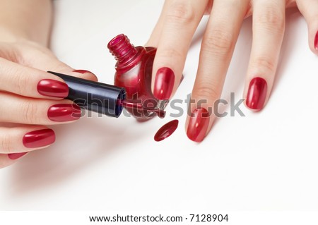 woman applying red nail polish