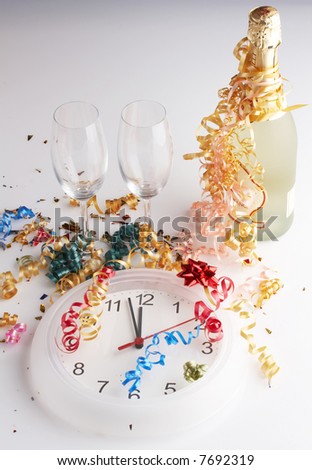Champagne bottle,  empty glasses, clock and confetti on white background