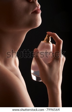 sensual woman applying perfume on her body, big white perfume bottle