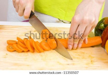 close-up of woman cutting carrots; preparing food