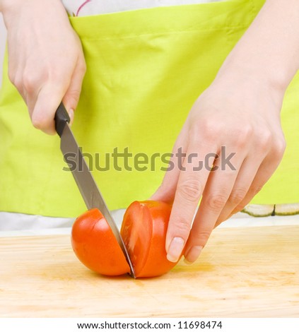 closeup of woman cutting tomato, preparing food