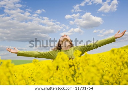 stock photo girl spreading her arms in the middle of a rapeseed field with 