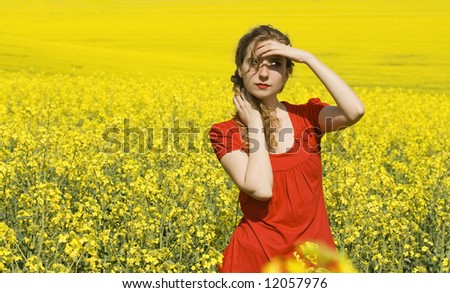 beautiful girl in the middle of a rapeseed(canola) field looking at the horizon in a sunny day  \'outdoor freedom\'