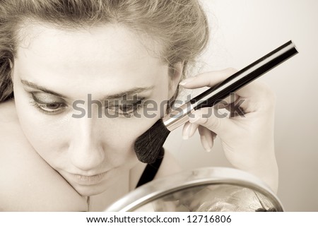 closeup of woman applying loose powder with thick black brush