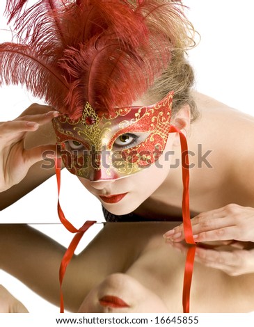 woman with red carnival mask looking in the mirror