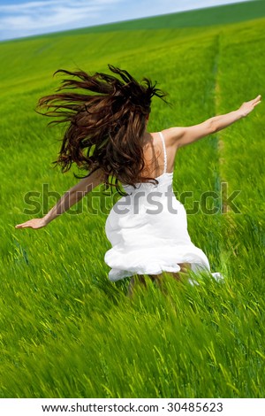 outdoor freedom;woman running with open arms in green field