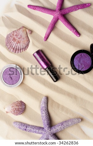 starfishes, purple eyeshadow and glitter on the sand; summer color trends concept