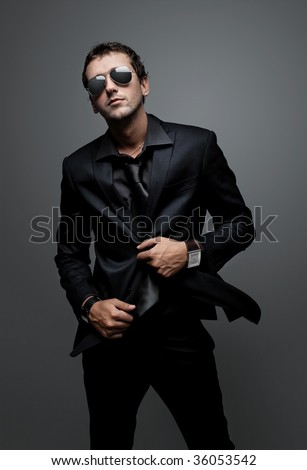 stock-photo-attractive-young-man-wearing-elegant-black-suit-and-sunglasses-36053542