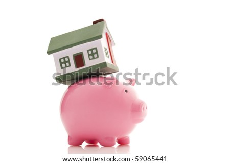 real estate concept; small house on a piggy bank