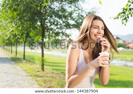 Pretty student girl drinking coffee at the park