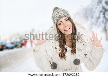 Happy cute Caucasian teenage girl with beanie hat and jacket outdoors in ski center. Winter travel concept.