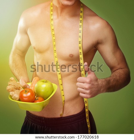 Handsome fit muscular young Caucasian man holding healthy food bowl. Closeup shot. Positivism, diet and healthy lifestyle.