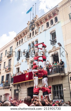 BARCELONA, SPAIN - AUGUST 17:  Group of people makes human tower in Festes de Gracia, Barcelona. Catalan human towers are on UNESCO\'s Cultural Heritage List. August 17, 2014 Barcelona.