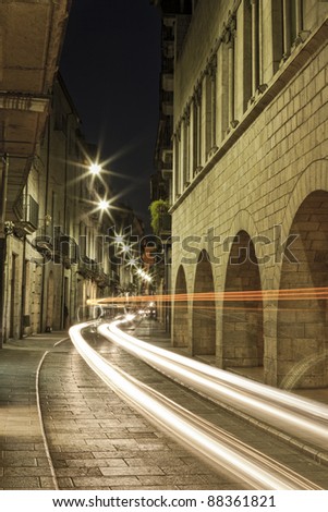 Night view of this great Girona street with car lights crossing the picture.