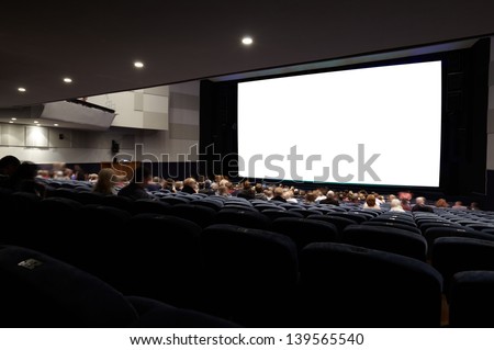 Cinema auditorium with people in chairs watching movie. Ready for adding your own picture. Diagonal perspective view.