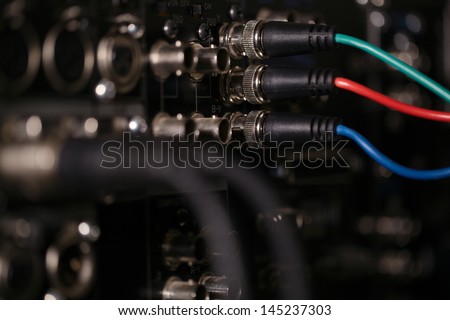 RGB video cables in the rear panel of the professional VCR. XLR audio cables in blur.
