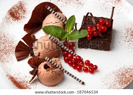 Restaurant dessert with chocolate ice-cream, cake and red currant decorated with chocolate chips
