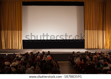 MOSCOW, RUSSIA - MARCH 8, 2013: Audience seated in an auditorium in front of a stage with a screen and open curtains waiting for the start of a film in the Circus of Dancing Fountains Aquamarine