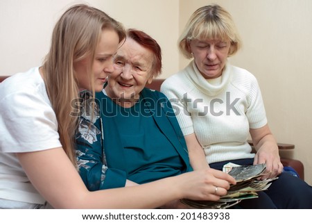Grandmother, mom and daughter happily bonding over old pictures