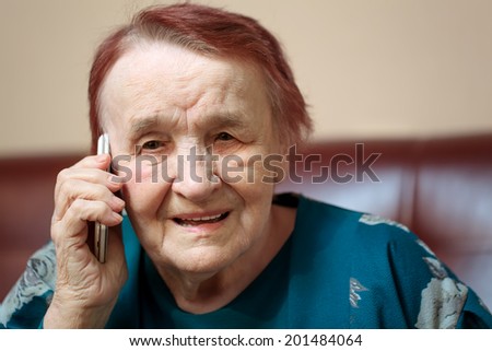Elderly lady talking on a mobile phone frowning in concentration as she listens to the conversation, close up of her face