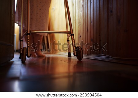 Elderly womans feet walking at home with aid of walker. Difficulty of life in old age