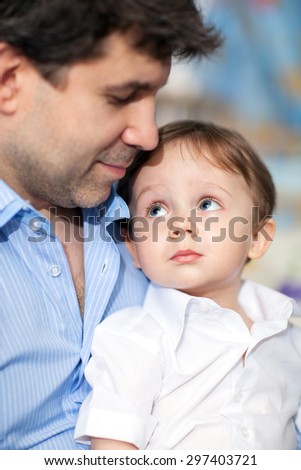 Happy young dad with a little son. Child looking at beloved father with his big blue eyes