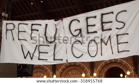 COPENHAGEN, DENMARK - SEPTEMBER 17, 2015: Handmade banner Refugees Welcome is hanged in Copenhagen railroad station by the place where locals bring clothes for refugees.