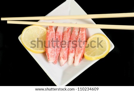 sushi fish sticks with lemon on a black background
