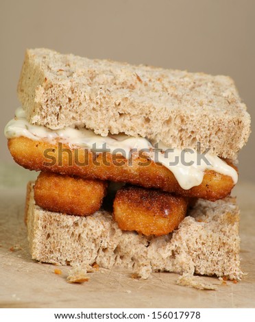 fresh grilled fish fingers with tartar sauce on a sandwich of wholemeal bread