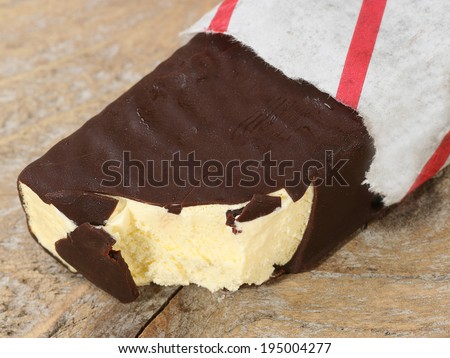 dark chocolate coated ice cream bar in a paper wrapper