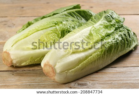 two hearts of romaine lettuce on a rustic wooden board