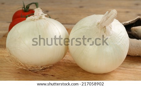 two white onions on a wooden board