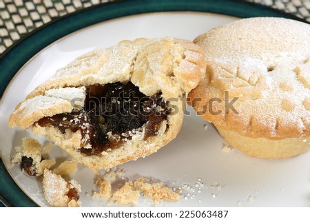two christmas mince pies with a bite missing