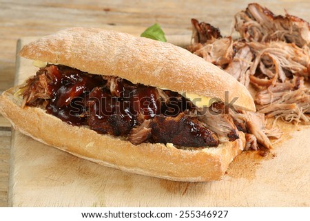 pulled pork with barbecue sauce on a crusty bread roll