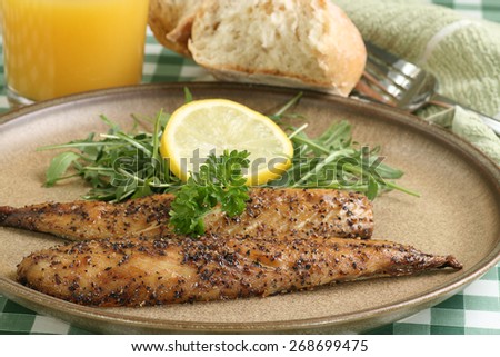 grilled peppered  mackerel fillets wit lemon and baby rocket leaves