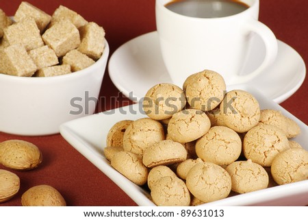 dish of amaretto biscuits coffee sugar and almonds on a red tablecloth