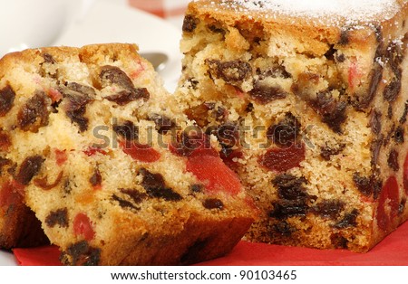 delicious sliced fruit cake with mixed fruit and cherries on a red napkin