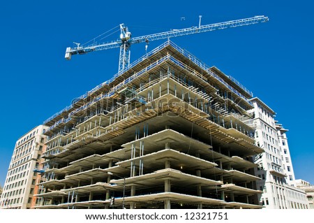 modern urban building under construction with a crane and blue sky