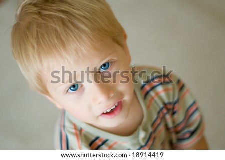 cute little boy with vivid blue eyes looks up