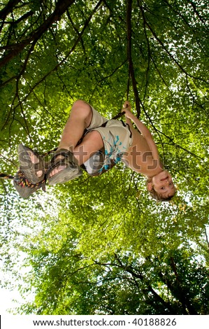 boy hanging from rope swing