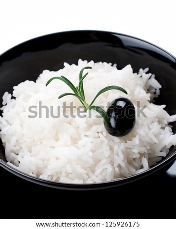 Cooked white rice in black bowl isolated close up