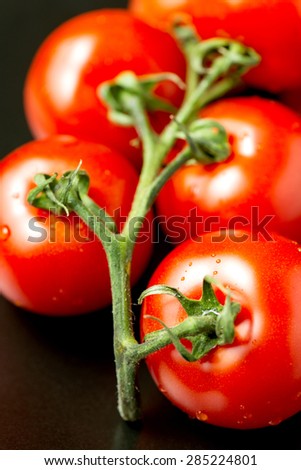 Bunch of tomatoes on black plate