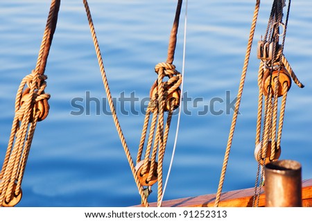 Sail yacht ropes and blocks on a water background