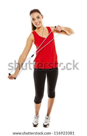 Young pretty fit woman exercising with elastic fitness band while listening music. Studio Isolated on white. High key