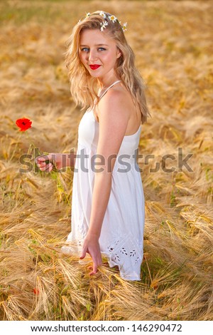 Portrait of pretty young woman at wheat field, a girl against golden wheat background expressing calmness emotions