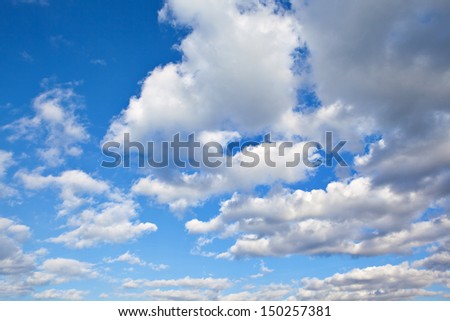 Blue sky background with the fluffy white clouds. Horizontal orientation
