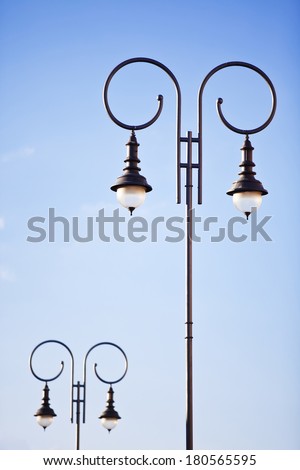 Old fashion decorative lamp post on the background of blue sky