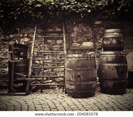 Ancient traditional wine press and oak barrels on Italian street outside restaurant. Traditional old technique of wine-making.